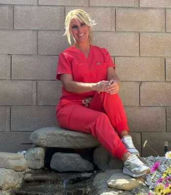 Dettycated Head Spa Northridge – relaxing outdoor portrait of professional head spa therapist Professional head spa therapist in red uniform smiling outdoors at Dettycated Head Spa Northridge