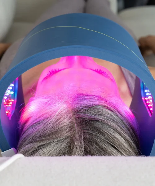 Client receiving soothing LED light therapy facial treatment at Dettycated Head Spa Northridge, promoting skin rejuvenation and relaxation.